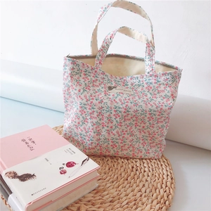 Detailed shot of floral cotton handbag on a straw mat with a literary aesthetic