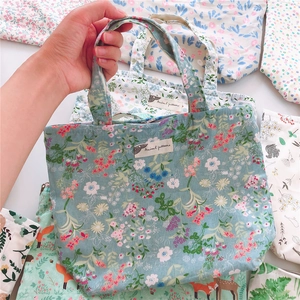 Close-up of floral print cotton handbag with zipper and Animal Patterns label detail