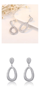 Close-up of silver S925 drop earrings with pave set zircon stones and elegant reflections
