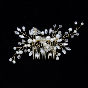 Elegant gold bridal hair comb with white pearls and sparkling crystals on black background