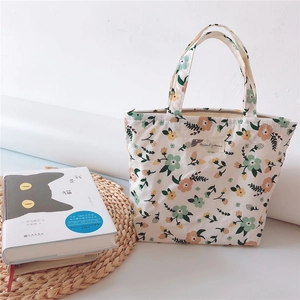 Detailed view of floral canvas tote bag with zipper closure and natural plant patterns
