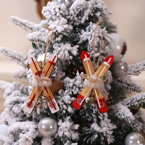 Wooden Christmas sled ornaments with snowflake prints and bells on a snowy tree