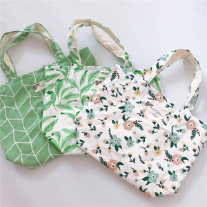 Flat lay of small cotton tote bags featuring floral and geometric leaf patterns with zippers