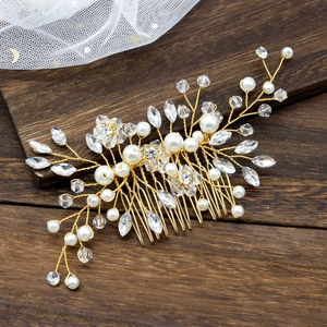 Detailed close-up of bridal hair comb with white pearls and crystals on golden wire
