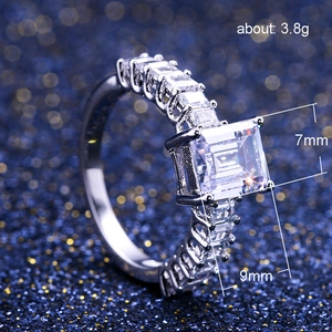 Elegant square emerald cut zircon ring with side stones on dark starry background