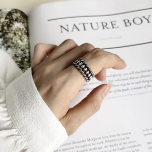 Detail shot of vintage 925 sterling silver woven ring worn on finger over an open book