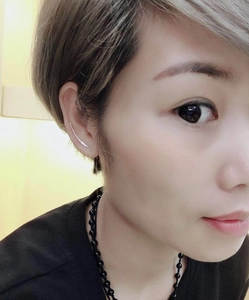 Macro detail of a silver U-shaped curved ear cuff on model with a textured finish