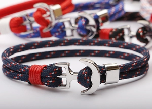 Detailed close-up of a nautical anchor bracelet made of red white and blue paracord rope