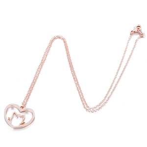 Macro detail of rose gold heart pendant with hollow cat silhouette on fine chain