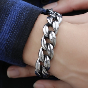 Men's titanium steel Cuban link bracelet styled on wrist with blue checkered shirt
