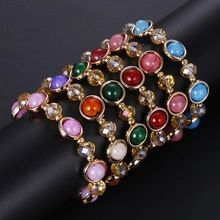 Detail of colorful beads and rainbow crystals set on a gold adjustable ring band