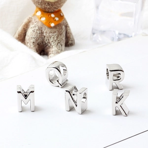 Close-up of silver alphabet beads M N Q R K for DIY jewelry bracelet making