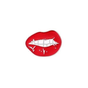 Macro shot of red enamel lips brooch badge with polished silver teeth and metal edges