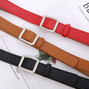 Detail view of slim leather belts in red, brown and black with square silver buckles