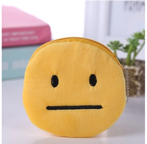 Macro detail of a plush yellow emoji coin purse with zipper and metal ball chain