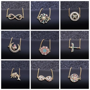Vista dettagliata di nove bracciali placcati in oro con ciondoli di zirconi colorati