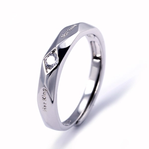 Macro detail of silver adjustable ring with faceted design and Her King engraving