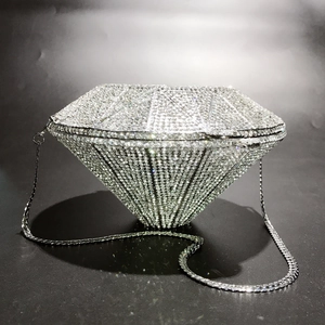Macro detail of silver diamond-shaped evening clutch with shimmering crystal rhinestones