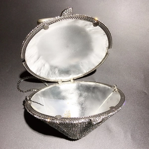 Detail of diamond-shaped clutch with crystal embellishment and silver chain strap