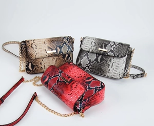 Detail view of snakeskin pattern crossbody bags with gold chain straps in multiple colors