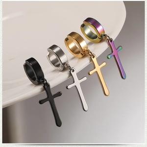 Macro view of cross dangle earrings in black, silver, gold and rainbow stainless steel