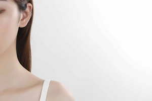 Close-up of three-layer silver ear cuff on ear, minimalist chic non-piercing design