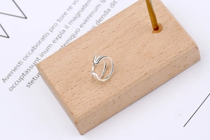 Close-up of triple-layered S925 sterling silver ear cuff displayed on wooden block