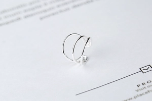 Macro detail of a minimalist triple-layer S925 sterling silver ear cuff with no piercing