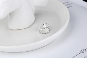 Detail of minimalist S925 sterling silver three-layer ear cuff on white ceramic tray