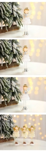 Détail d'anges de Noël décoratifs avec jupes à franges, ailes pailletées et étoiles d'or