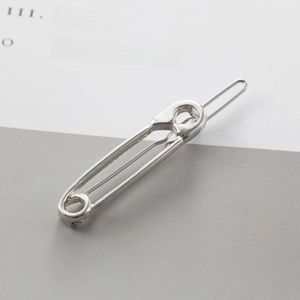 Close-up of a silver safety pin hair clip with a polished finish on a neutral background