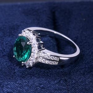 Elegant halo engagement ring with oval green gemstone and white zircon stones in silver metal