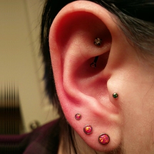 Close-up of pink opal labret stud set in black metal base worn on earlobe for detail