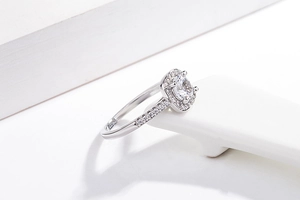 Macro shot of silver plated square cut ring with pavé diamonds on a white ceramic stand