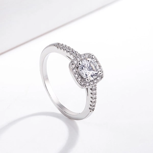 Detail of a square-cut halo zircon ring with small side stones in a platinum finish