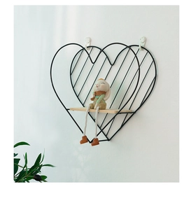 Detalle de estante de pared de metal negro en forma de corazón con base de madera y conejo