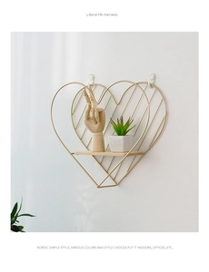 Detalle de estante de pared con forma de corazón de metal dorado y tabla de madera clara