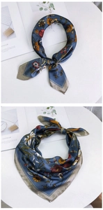 Detail view of blue floral silk scarf showing premium satin texture and nature prints