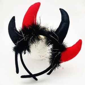Detail of glitter devil horn headbands with black feathers and shimmering silver tinsel trim