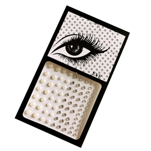 Close-up of DIY self-adhesive face gems and white half pearls on card for makeup art