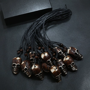 Handcrafted tribal resin skull pendant necklace with black cord and brown beads