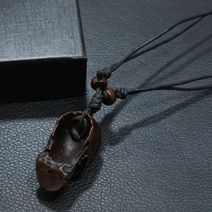 Handwoven tribal necklace with a carved dark resin skull pendant on adjustable black rope