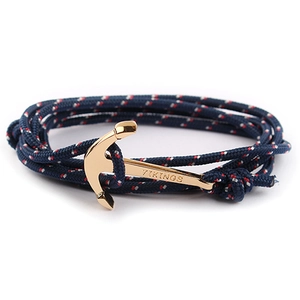 Close-up of blue nylon cord bracelet featuring a gold-plated Viking anchor clasp