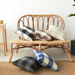 Set of five farmhouse plaid throw pillow covers in linen blend on a woven bench