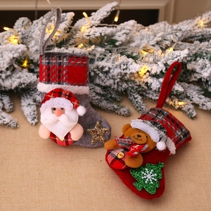 Pair of Christmas mini stockings with Santa and bear figures on snowy pine background
