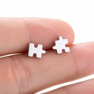 Minimalist silver geometric puzzle-shaped stud earrings with a polished metallic finish