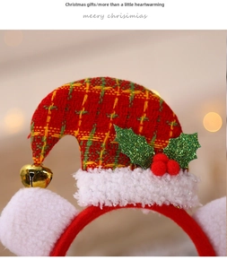 Détail d'un serre-tête chapeau de Noël à carreaux rouges avec une cloche dorée