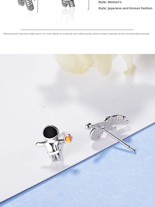 Detailed view of astronaut earrings with silver finish and yellow cubic zirconia stones