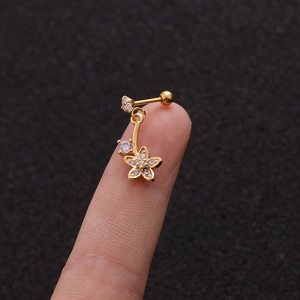 Close-up of a gold flower stud earring with micro-pave cubic zirconia on finger