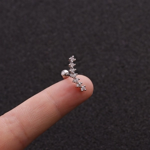 Macro shot of silver curved tragus stud featuring seven micro-pave cubic zirconia crystals